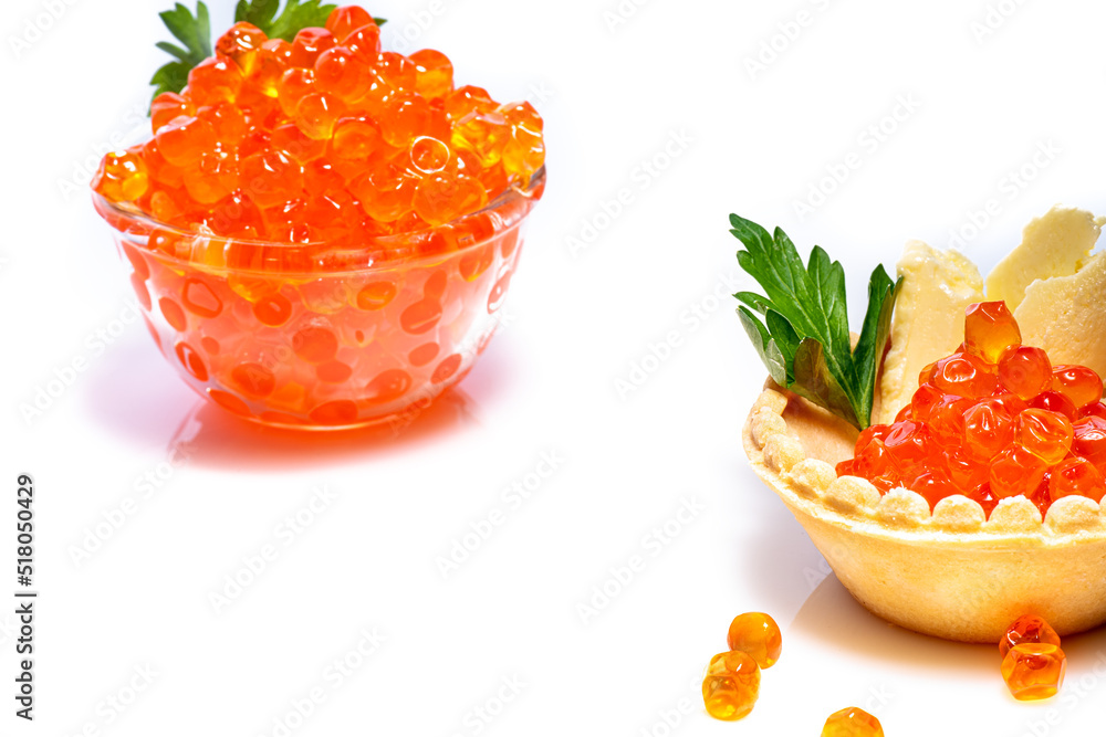 Red caviar in small glass cup decorated with parsley on top and caviar in tartlet with butter and also with parsley on white background. Red caviar in cup and tartlet. Red caviar in small glass cup decorated with parsley on top and caviar in tartlet with butter and also with parsley on white background. Red caviar in cup and tartlet.