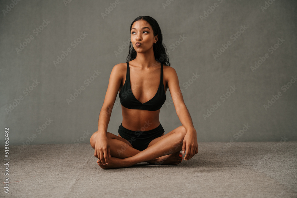 Young Multiethnic female blowing kisses while posing in the studio Young Multiethnic female blowing kisses while posing in the studio