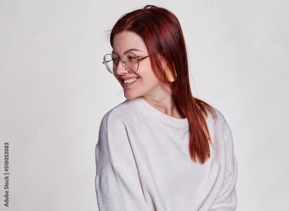 Smiling redhead woman in big eyeglasses with pierced tunnel in ears posing over white background copy space Smiling redhead woman in big eyeglasses with pierced tunnel in ears posing over white background copy space
