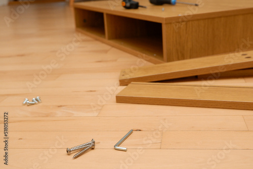 Assembly of furniture, the different parts and pieces of furniture arranged on the wooden floor. DIY furniture assembly concept