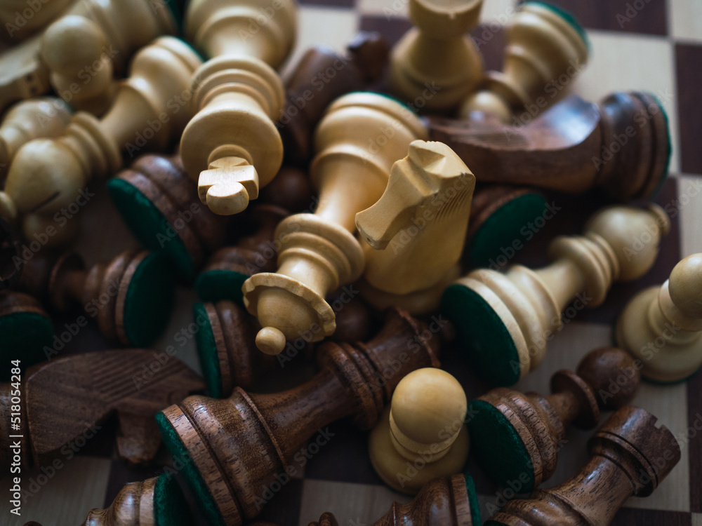 Top view of wooden chess pieces scattered across the board Top view of wooden chess pieces scattered across the board
