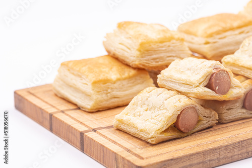 Puff pastry on the serving wooden board isolated above white background