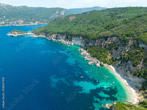 Aerial view of Kolias Beach on the island of Corfu. Greece. Cliffs overlooking the beach and an uncontaminated green and blue sea. Moored boats © Naeblys
