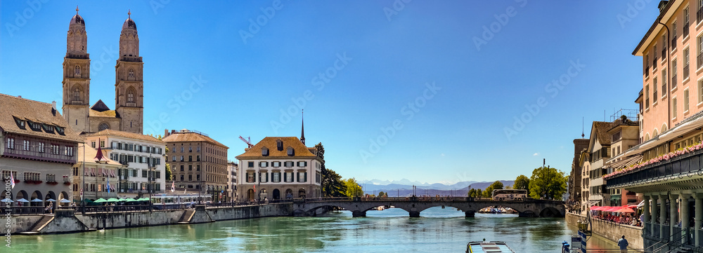 Naklejka premium Poster-Ansicht von Zürich mit der Promenade am Limmatquai, dem Großmünster und dem Blick auf die Alpen, Zürich, Schweiz