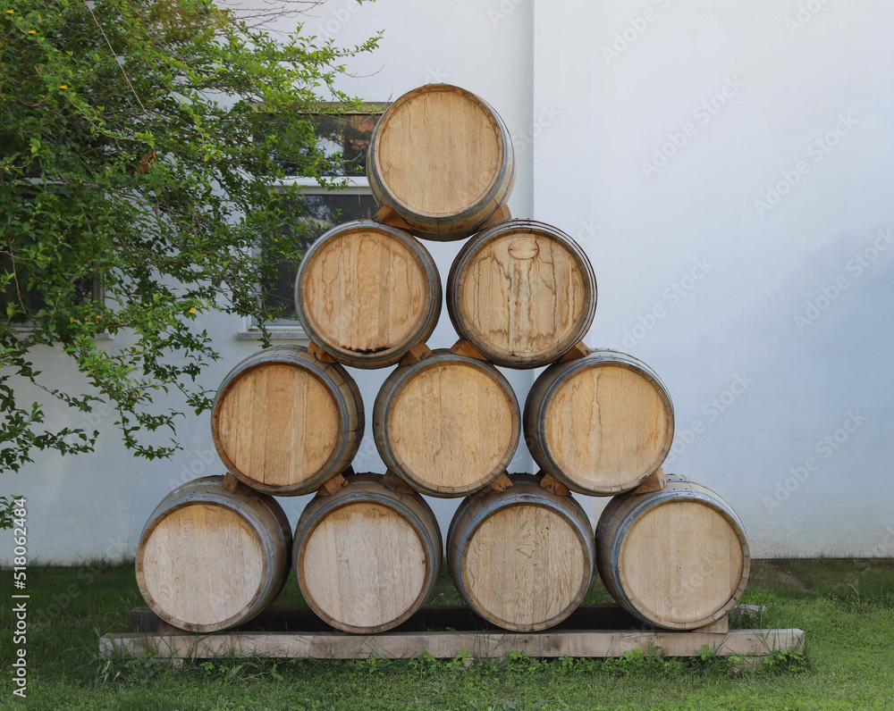 Wine barrels arranged outdoors in the shape of a pyramid for visual purposes. For cafe or restaurant. Mockup Free space to write messages or advertisements

