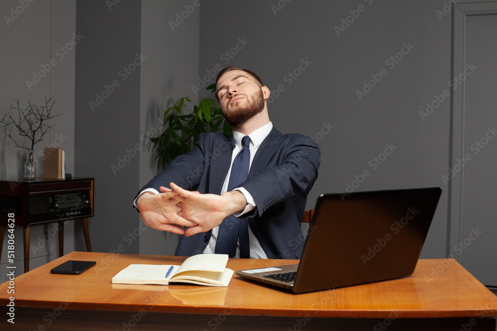 Tired hardworking handsome businessman sitting in office late at night. Overworking concept. Tired hardworking handsome businessman sitting in office late at night. Overworking concept.