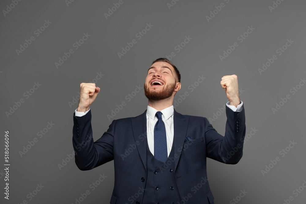 Young adult businessman having fun against grey studio wall background. Business win, fun and success concept Young adult businessman having fun against grey studio wall background. Business win, fun and success concept