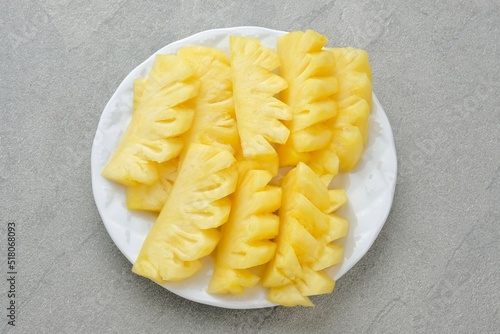 Fresh slices pineapple served in white plate 