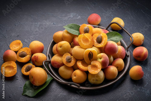 Fresh Apricot fruit with leaf on wooden background, Yellow Apricot on black plate over wooden Background.