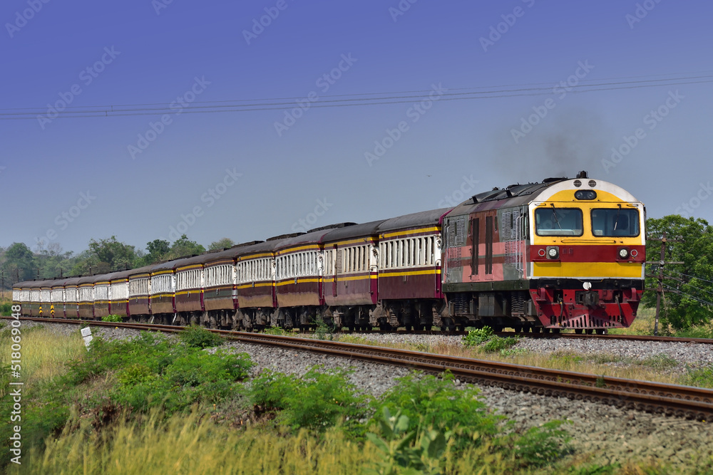 Passenger train by diesel locomotive on the railway in Thailand