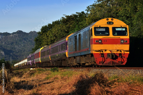 Passenger train by diesel locomotive on the railway in Thailand
