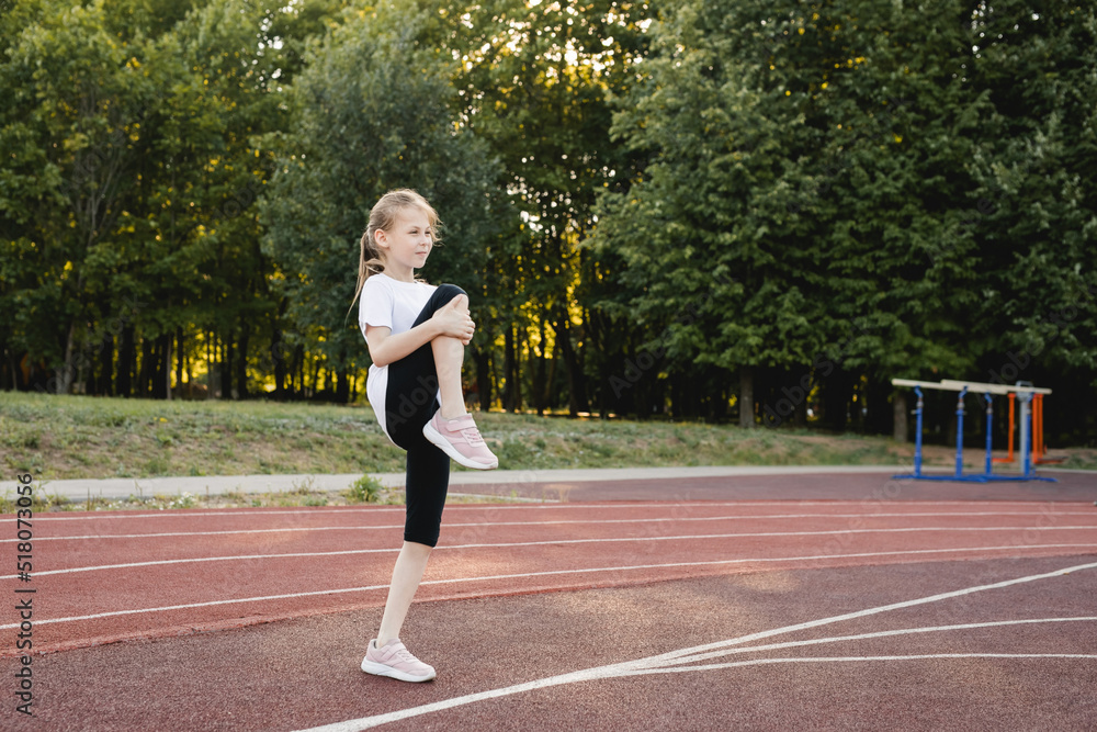 Child girl doing warm-up exercises before running Child girl doing warm-up exercises before running