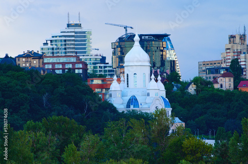 Close-up view of white colored building of the baptist Church "Temple of Peace" in Kyiv. Modern multi-story apartment buildings in the background. Stormy sky and gloomy clouds