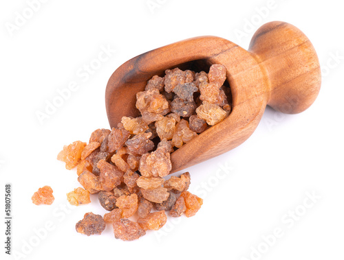 Myrrh resin in wooden scoop, isolated on white background. Pile of natural Commiphora myrrha. Sweet Myrrh Opoponax. Incense. photo