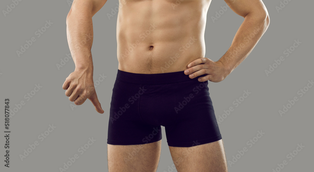 Guy in underwear showing thumbs down standing isolated on grey background.  Young male has trouble with intimate matters. Man has difficulty getting  erection. Erectile dysfunction and impotence concept Stock 写真 | Adobe