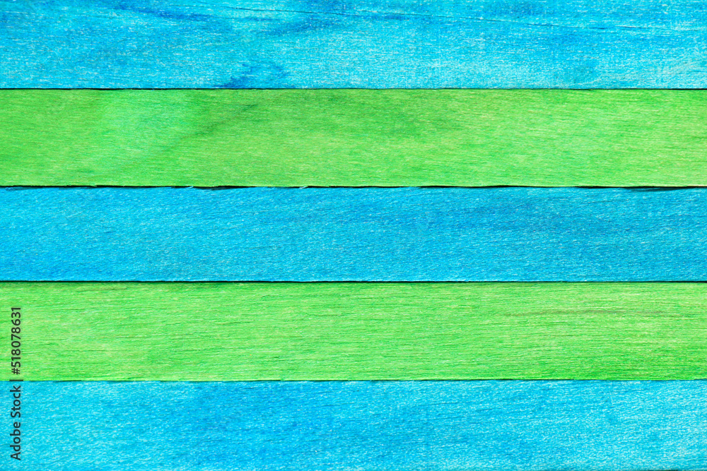Horizontal retro background of alternating painted wooden boards in green and blue colours. Wooden textured backdrop in two colors. Colored wooden textured planks with natural structure.