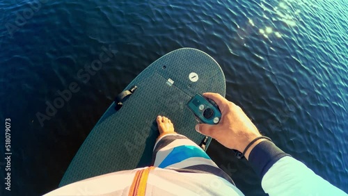 Young man riding an electrofoil.Foil Surfing in first person.Man standing on an electric Board.