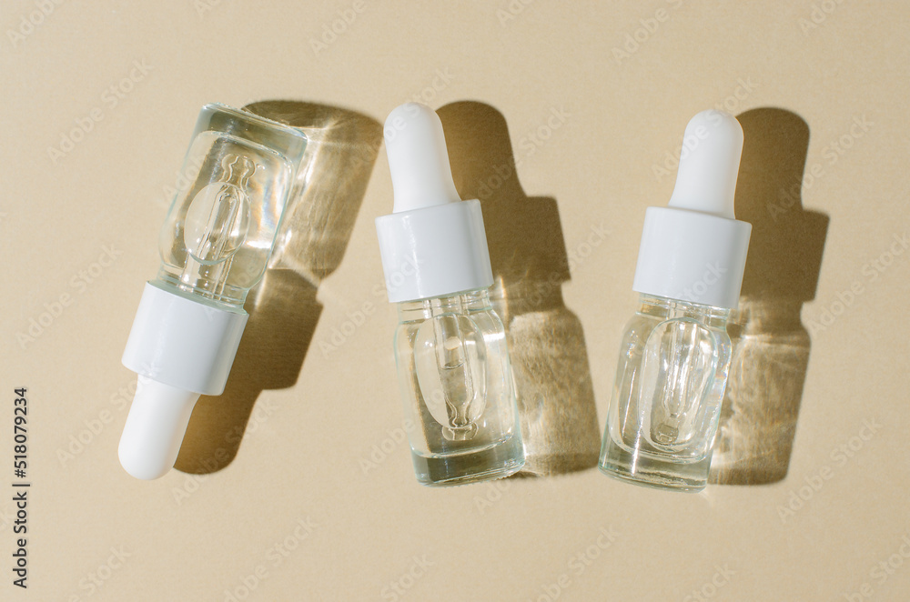 Cosmetic product in a bottle with a pipette. Serum for skin or hair. Flat layout. Beige background. Cosmetic product in a bottle with a pipette. Serum for skin or hair. Flat layout. Beige background.