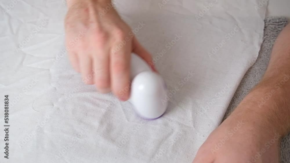 The man removes fabric pills using lint shaver. The man removes fabric pills using lint shaver.