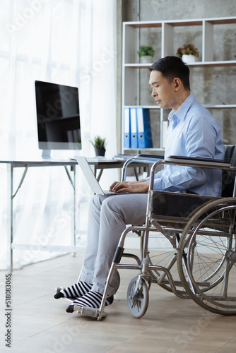 Man sitting on a wheelchair, man with a wheelchair at company office, Working together as a team in a large organization. The concept of team management is diverse.