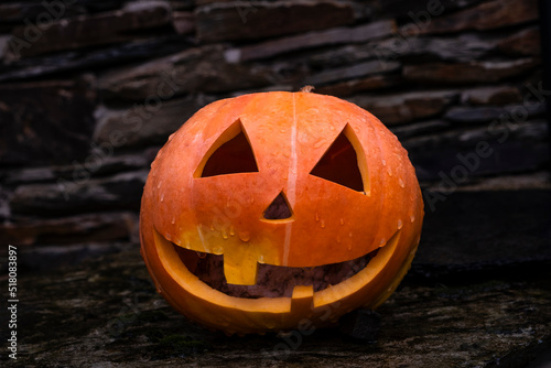 Halloween Jack-o'-lantern, carved pumpkin with a scary grinning face photo