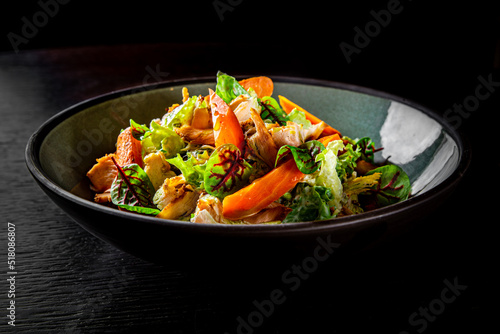 Chicken, carrot, lettice and tomato salad on bowl