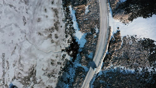 Wallpaper Mural Aerial Top Down View Tracking Van Car Driving Moving in Winter on Curved Road Through Wild Snowy Rocky Lands and Frozen Wetlands in Búlandstindur Mountain Area, Iceland Torontodigital.ca