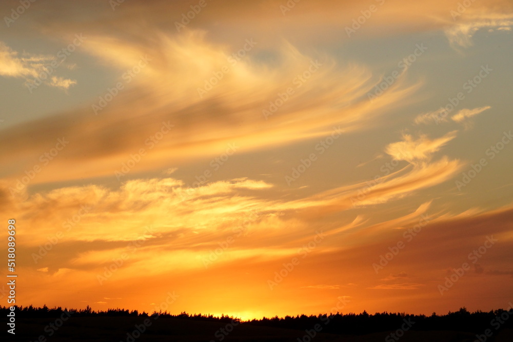 Bright multi-colored clouds are in the sky just after sunset. Bright multi-colored clouds are in the sky just after sunset.