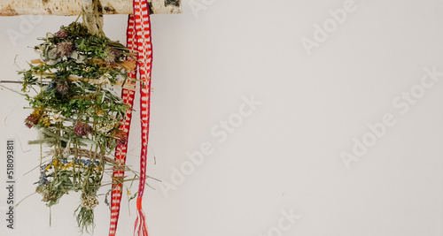 heritage craft concept. panel of meadow herbs with red amulet belt on white background