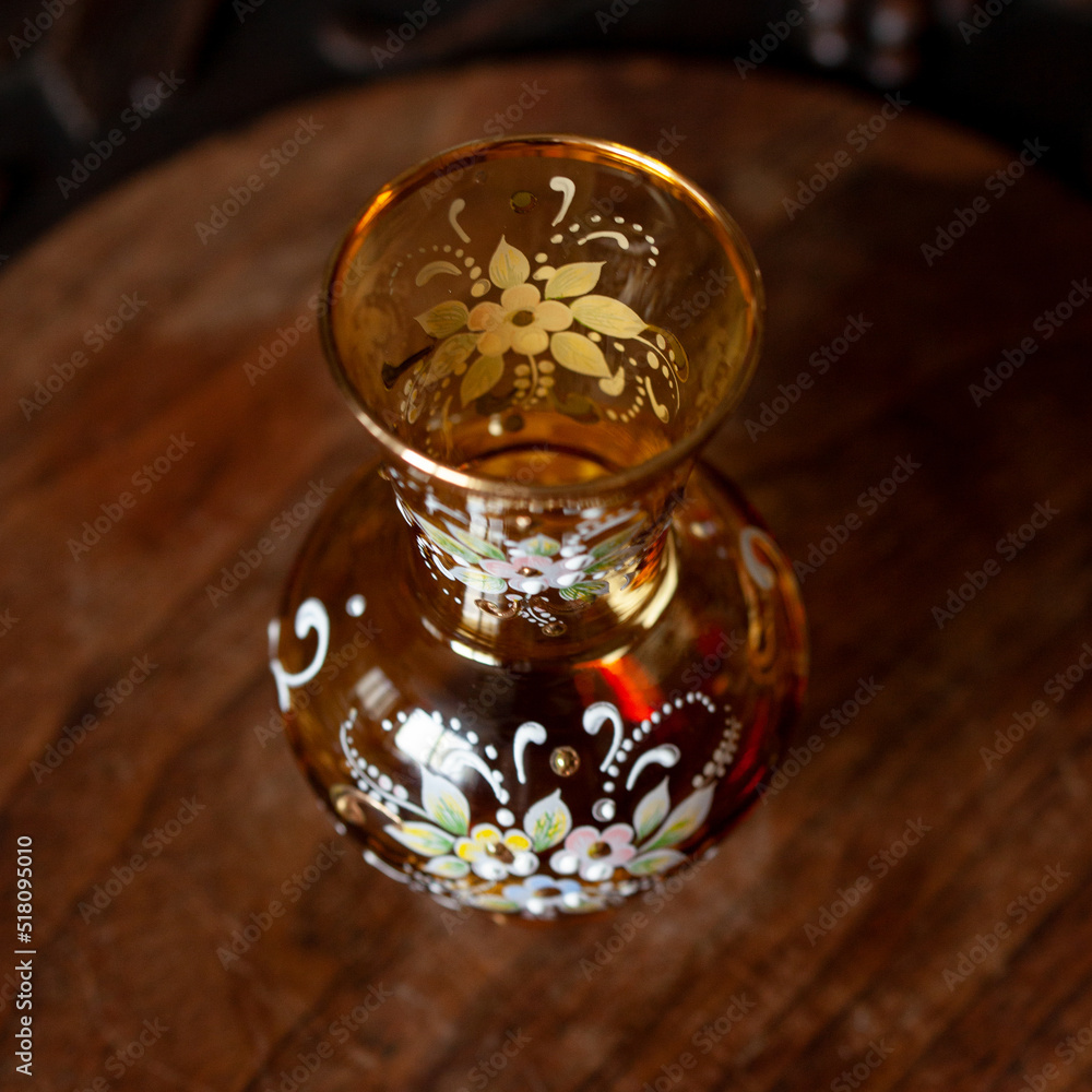 antique orange glass vase with flower pattern in luxury interior. hand-painted crystal vase