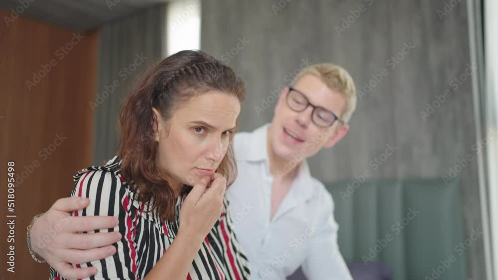 Loving husband comforting troubled wife sitting on bed at home, showing love and support. Loving husband comforting troubled wife sitting on bed at home, showing love and support.