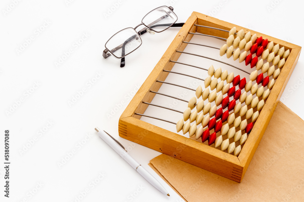 Accounting wooden abacus with blank sheet of paper. Financial calculations concept Accounting wooden abacus with blank sheet of paper. Financial calculations concept