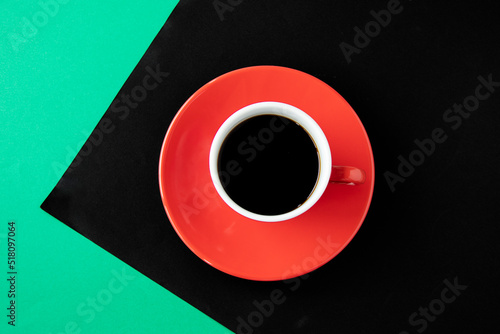 緑と黒の紙の上の赤いコーヒーカップのコーヒー