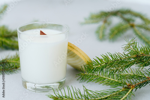 Soy candles in transparent glass jar with wooden lid. Candle on light background close-up.