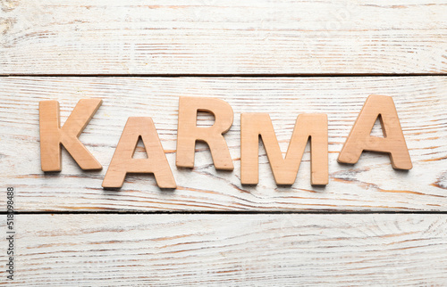 Word Karma made with letters on white wooden background, top view