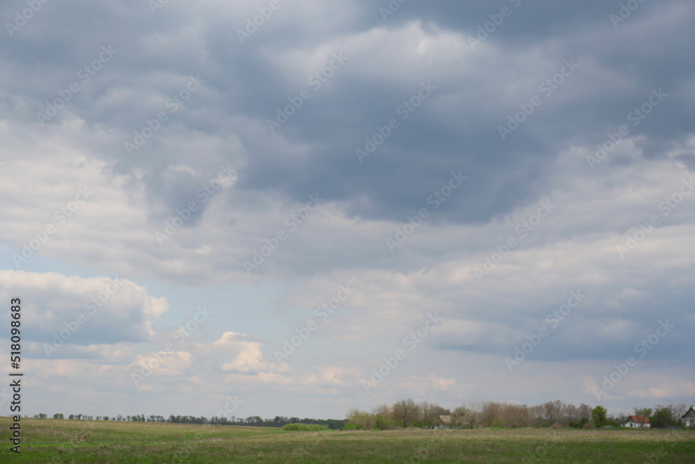 Houses under cloudy sky. Picturesque rural landscape