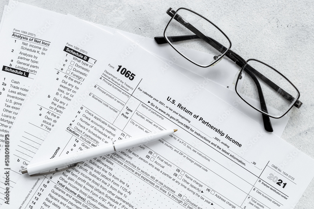US individual tax form with pen and glasses on businessman table US individual tax form with pen and glasses on businessman table