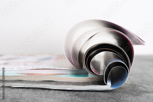 Fotografiet Three open magazines on grey stone table, closeup