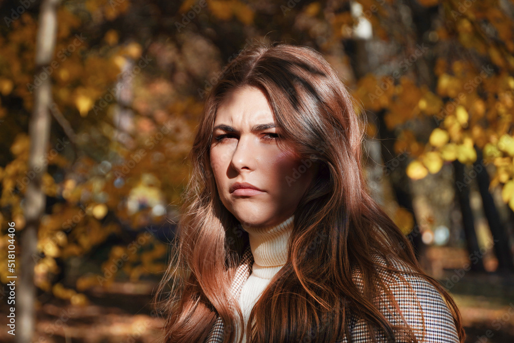 Sad angry young woman at autumn park. Stress loneliness young person concept.
