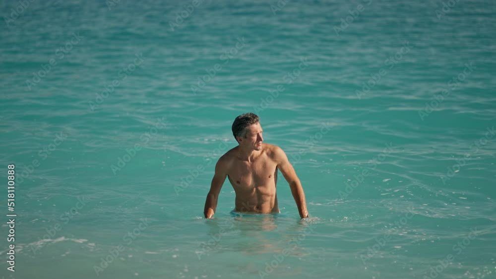 slow motion of muscular athletic man on beach in turquoise water of mediterranean sea in Oludeniz Beach in Aegean Sea after swimming. Summer tourist Season Fethiye, Mugla Turkey slow motion of muscular athletic man on beach in turquoise water of mediterranean sea in Oludeniz Beach in Aegean Sea after swimming. Summer tourist Season Fethiye, Mugla Turkey