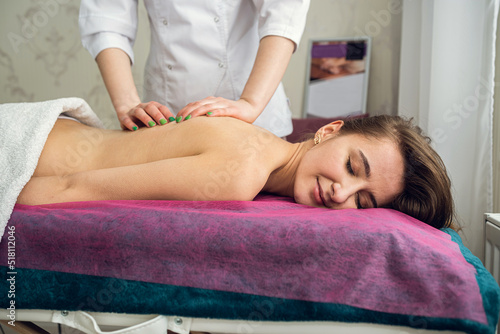 Young woman lying on table and receive relax massage on spa
