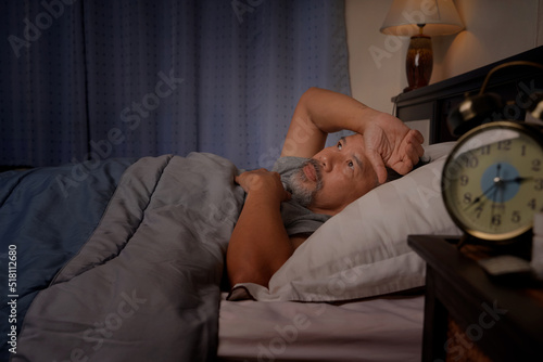 depressed old man and stressed lying in bed from insomnia
