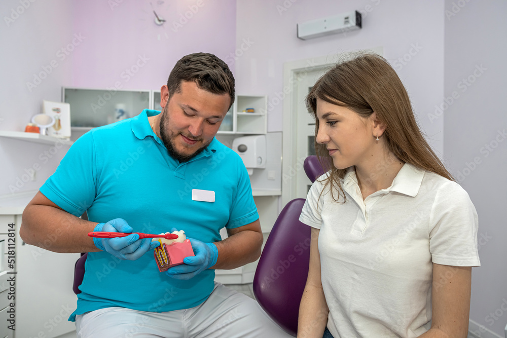 Fototapeta premium male dentist explains the plan for further dental treatment to female patient in the clinic