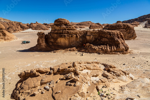 Car in White Canyon in Sinai. Yellow and orange sandstone textured carved mountain, bright blue sky. Egyptian desert landscape. Sinai peninsula, Egypt