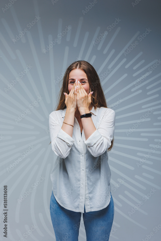 Young long-haired woman in jeans and a white shirt on a plain background. Emotions on a woman's face Young long-haired woman in jeans and a white shirt on a plain background. Emotions on a woman's face