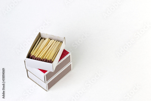 Stack of match boxes with an open box on top isolated on a white background with space for text