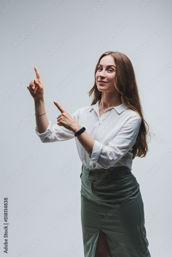 Smiling woman in white shirt recommends opt for advertising index finger to side on workspace, commercial promo area, copy space mockup isolated on white background Smiling woman in white shirt recommends opt for advertising index finger to side on workspace, commercial promo area, copy space mockup isolated on white background