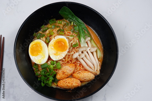 Delicious ramen with boiled egg,mushroom and vegetable  in black bowl 