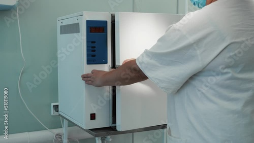 Wallpaper Mural Female nurse in white uniform opening medical autoclave steam sterilizer machine, clean surgical instruments inside, healthcare worker preparing for surgery in hospital operating room, slow motion. Torontodigital.ca