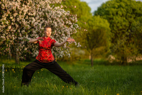 Asian woman train with tai chi in the park in the evening, chinese martial arts, healthy life care concept. © Pavel